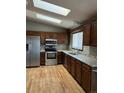 Kitchen with wood cabinets, stainless steel appliances, and granite countertops at 18269 E Hampden Pl, Aurora, CO 80013