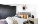 Inviting bedroom with a dark brick accent wall, a gray upholstered bed, and warm-toned bedding at 1253 S Yosemite Way # 94, Denver, CO 80247