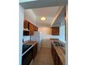 Galley-style kitchen with wood cabinets, white appliances, and laminate counters at 467 S Memphis Way # 17, Aurora, CO 80017