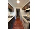 Galley kitchen with wood cabinets, stainless steel appliances, and hardwood floors at 364 S Ironton St # 419, Aurora, CO 80012