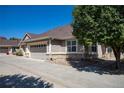 Exterior view of a tan house with a two-car garage at 7591 S Addison Way, Aurora, CO 80016