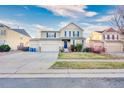 Two-story house with beige siding, double garage, and front yard at 10049 Granby Dr, Commerce City, CO 80022