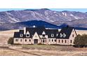Brick estate home with a grand entrance and mountain backdrop at 7755 Moore Rd, Littleton, CO 80125