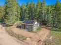 Secluded log cabin with solar panels in a wooded area at 9719 Beaver Pond, Conifer, CO 80433