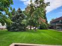 Expansive green space with mature trees and building exteriors at 8870 W Jewell Ave # 14, Lakewood, CO 80232