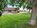 Large backyard with lush green grass and mature trees at 8870 W Jewell Ave # 14, Lakewood, CO 80232