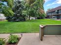 Green lawn, mature trees, and building exteriors create a serene community atmosphere at 8870 W Jewell Ave # 14, Lakewood, CO 80232