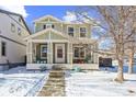 Two-story house with light green exterior and snowy yard at 4325 S Hoyt St, Littleton, CO 80123