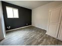 Spacious bedroom with dark accent wall and laminate wood flooring at 1522 Tamarac St, Denver, CO 80220