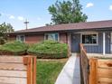 Brick home with a gray door and landscaped yard at 6325 Martin Luther King Jr Blvd, Denver, CO 80207