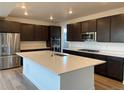 Modern kitchen with large island, stainless steel appliances, and dark brown cabinetry at 1040 Sunrise Dr, Erie, CO 80516