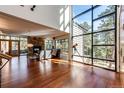 Bright and spacious living room with hardwood floors, stone fireplace, and large windows at 32651 Buffalo Creek Rd, Evergreen, CO 80439