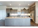 Modern kitchen with large island and stainless steel appliances at 7292 Xenophon Ct, Arvada, CO 80005