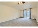 Bright bedroom with gray carpet, sliding door to balcony, and ceiling fan at 655 S Clinton St # 10B, Denver, CO 80247