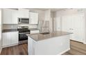 Modern kitchen with white cabinets, stainless steel appliances, and an island at 3030 Oxley St, Strasburg, CO 80136