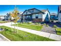 Ranch style home with gray siding, stone accents, and a landscaped front yard at 8860 S Quatar Ct, Aurora, CO 80016