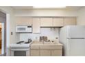 Small kitchen with white appliances and light-colored cabinetry at 1020 15Th St # 25F, Denver, CO 80202