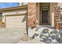 Two-story house with beige siding, brick pillars, and attached garage at 10288 Salida St, Commerce City, CO 80022