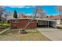 Brick ranch home with attached carport and mature tree in front at 28 W Broadmoor Dr, Littleton, CO 80120
