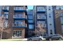 Front view of a multi-story building with blue balconies and brick exterior at 1488 Madison St # 211, Denver, CO 80206