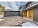 Two-car garage and entryway with modern wood and gray siding at 1298 Silverheels Dr, Larkspur, CO 80118