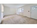 Spacious living room featuring carpeted floors and a window at 428 S Uvalda St, Aurora, CO 80012