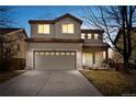 Two-story house with attached garage, illuminated at night at 5241 S Shawnee St, Aurora, CO 80015