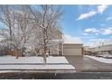 Two-story house exterior, snow-covered lawn and driveway at 15585 E 99Th Ave, Commerce City, CO 80022