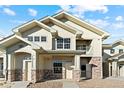 Two-story townhome with light-colored siding and stone accents at 18633 Stroh Rd # 1-106, Parker, CO 80134