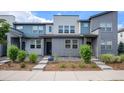 Modern townhome exterior with gray and teal siding, landscaping, and walkway at 16231 E Warner Pl, Denver, CO 80239
