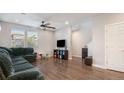 Spacious living room with hardwood floors, a green sectional sofa, and a ceiling fan at 16231 E Warner Pl, Denver, CO 80239