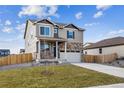 Two-story house with stone and siding exterior, two-car garage, and landscaped yard at 4355 Cattle Cross Trl, Castle Rock, CO 80104