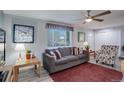 Cozy living room featuring a gray sofa, patterned armchair, and warm wood tones at 14696 E Hawaii Pl, Aurora, CO 80012