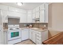 Well-equipped kitchen with white cabinets and tile backsplash at 690 S Alton Way # 1C, Denver, CO 80247