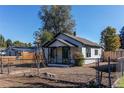 White bungalow with green door, garden, and windmill at 4768 S Galapago St, Englewood, CO 80110