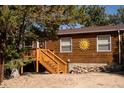 Ranch style home with wooden siding, deck, and stairs leading to the entrance at 76 Wonderland Ave, Golden, CO 80403