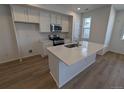 Modern kitchen featuring white cabinets, island, stainless steel appliances, and light flooring at 8489 Eagle River St, Littleton, CO 80125