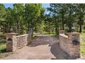 Elegant stone driveway entrance with tall pillars and lighting at 17075 Viscount Ct, Monument, CO 80132