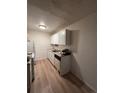 Bright kitchen featuring white cabinets, wood-look floors, and modern appliances at 10772 E Exposition Ave # 141, Aurora, CO 80012