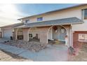 Brick entryway with arched covered porch and a gray door at 3601 Sunrise Ln, Brighton, CO 80603
