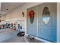 Gray front door with a glass oval window and fall wreath at 3601 Sunrise Ln, Brighton, CO 80603
