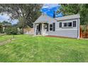 Quaint bungalow home with gray siding, lush lawn, and walkway at 4848 Hooker St, Denver, CO 80221