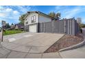 Contemporary home with gray siding, a large driveway, and a fenced yard at 3701 S Spruce St, Denver, CO 80237