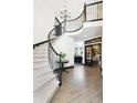 Elegant curved staircase with wrought iron railings and a chandelier at 1563 Baguette Dr, Castle Rock, CO 80108