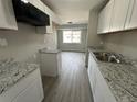 Modern kitchen with white cabinets, granite counters, and stainless steel sink at 17337 E Flora Pl, Aurora, CO 80013