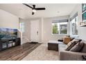 Living room with gray sectional sofa, large TV, and hardwood floors at 12772 Boggs St, Parker, CO 80134