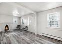 Bright living room featuring a fireplace and gray laminate floors at 2801 W Dartmouth Ave, Denver, CO 80236
