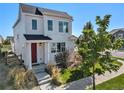 Two-story home with red door and landscaping at 12744 Crane River Dr, Longmont, CO 80504