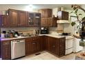 Dark wood cabinetry, stainless steel dishwasher and gas range at 106 Brook Rd, Evergreen, CO 80439