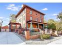 Brick two-story home with a classic design, inviting porch, and landscaped yard at 965 N Pennsylvania St, Denver, CO 80203